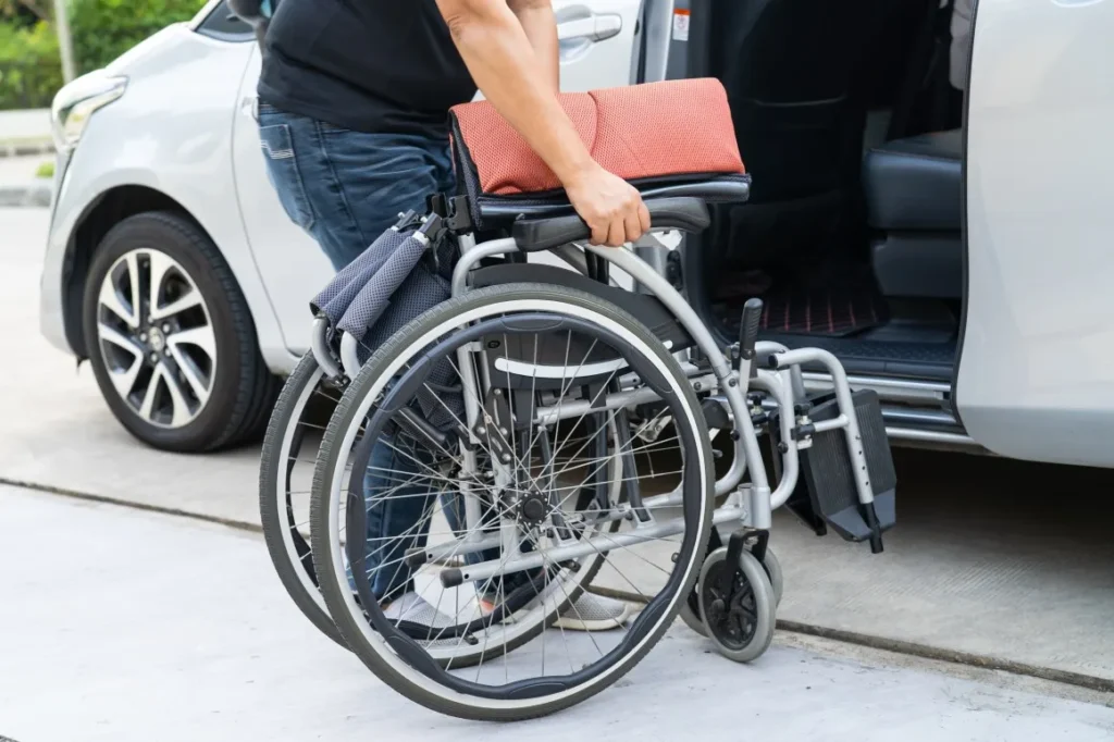 Close up of support worker putting wheelchair in van