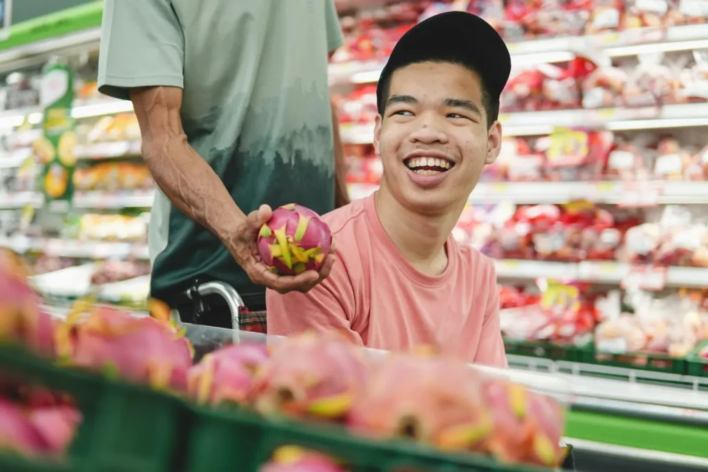 Disabled man grocery shopping with support worker