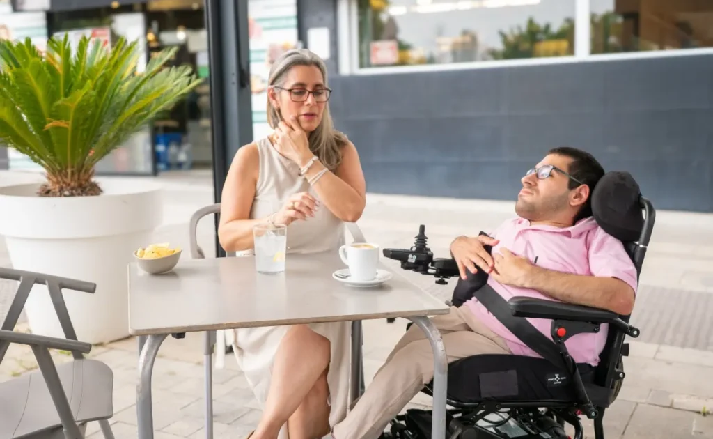 Disabled man at café with support worker